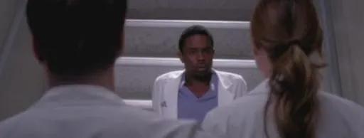 Un médico residente sentado frente a dos compañeros en Grey’s Anatomy