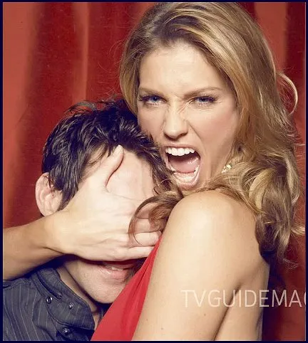 Ali Larter abrazando a un hombre por detrás tapándole los ojos