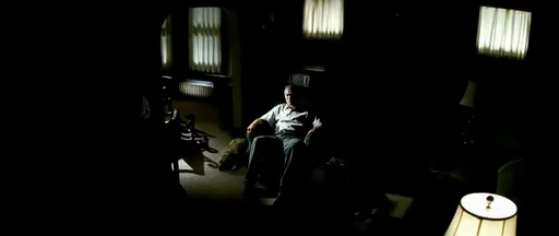 Walt Kowalski sentado a oscuras en su salón en Gran Torino