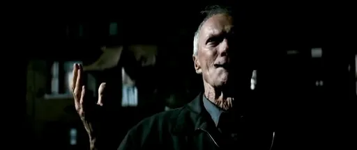 Clint Eastwood como Walt Kowalski en la penumbra en Gran Torino
