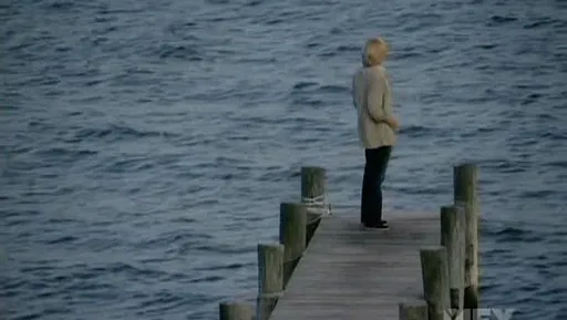 Patty Hewes de pie al final de un embarcadero mirando al mar en Damages
