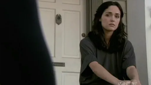 Ellen Parsons sentada en el suelo junto a una puerta en Damages