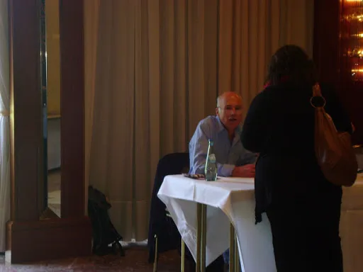 Michael Hogan sentado a una mesa con mantel blanco