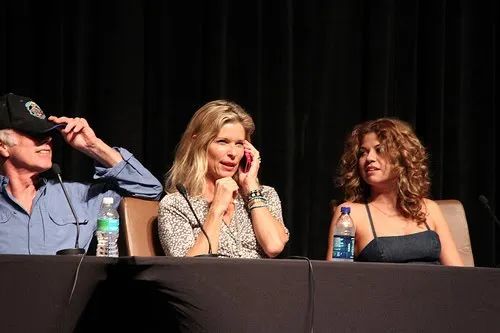 Michael Hogan con gorra, Kate Vernon y Luciana Carro en la mesa del panel