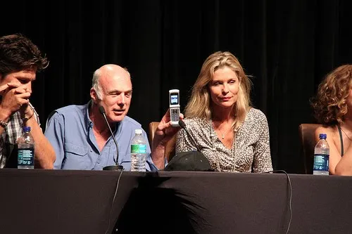 Michael Hogan enseña un móvil abierto durante el panel junto a Kate Vernon