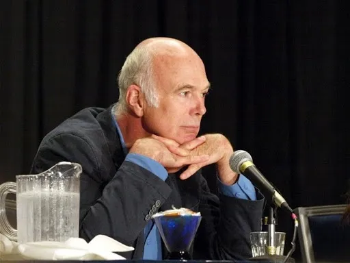 Michael Hogan escuchando con la barbilla apoyada en las manos durante el panel