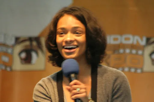 Kandyse McClure sonriendo con un micrófono en la London Expo