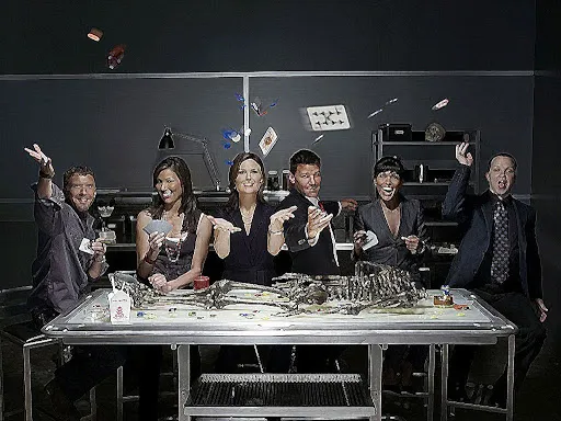El reparto de Bones posando alrededor de una mesa del laboratorio