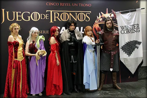 Grupo de fans disfrazados de personajes de Juego de Tronos junto a un estandarte Stark