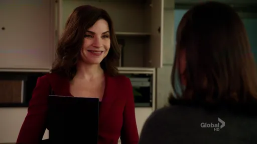 Alicia Florrick sonriendo con una carpeta en The Good Wife