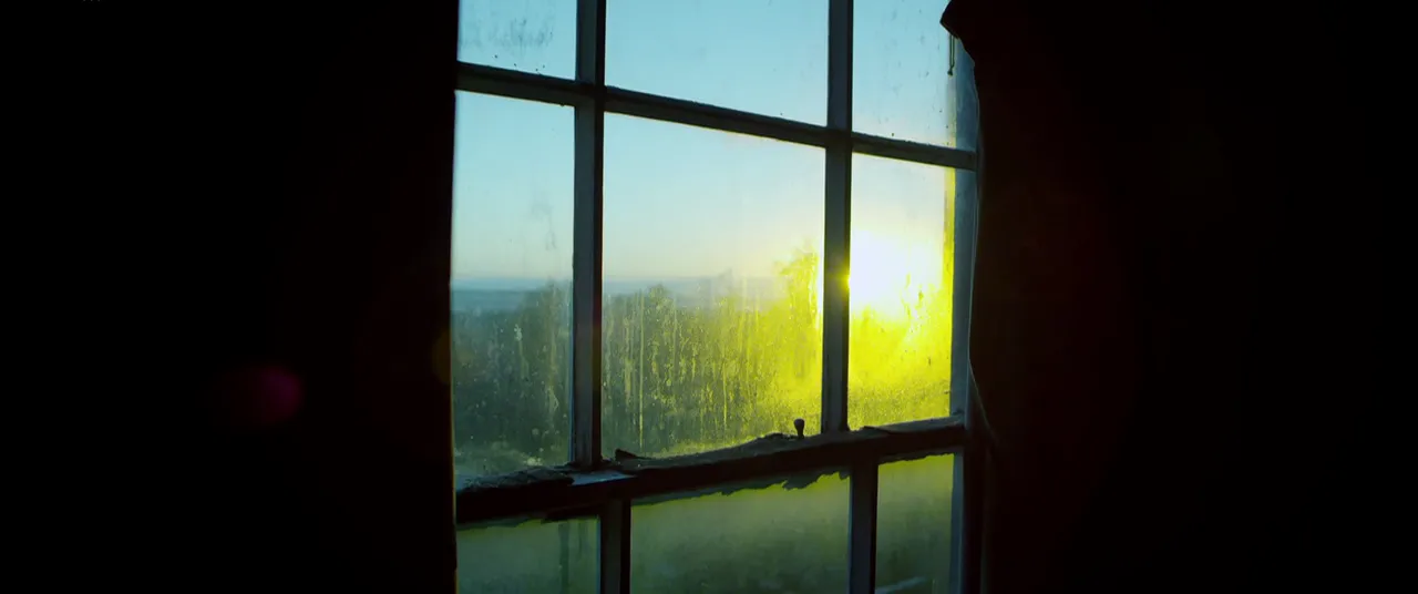 Una ventana con el sol entrando en una habitación a oscuras en Utopia