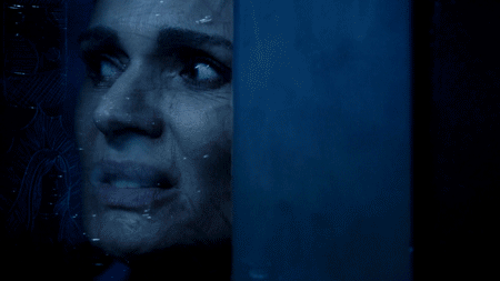 Rostro asustado de una mujer en la penumbra azul en Banshee