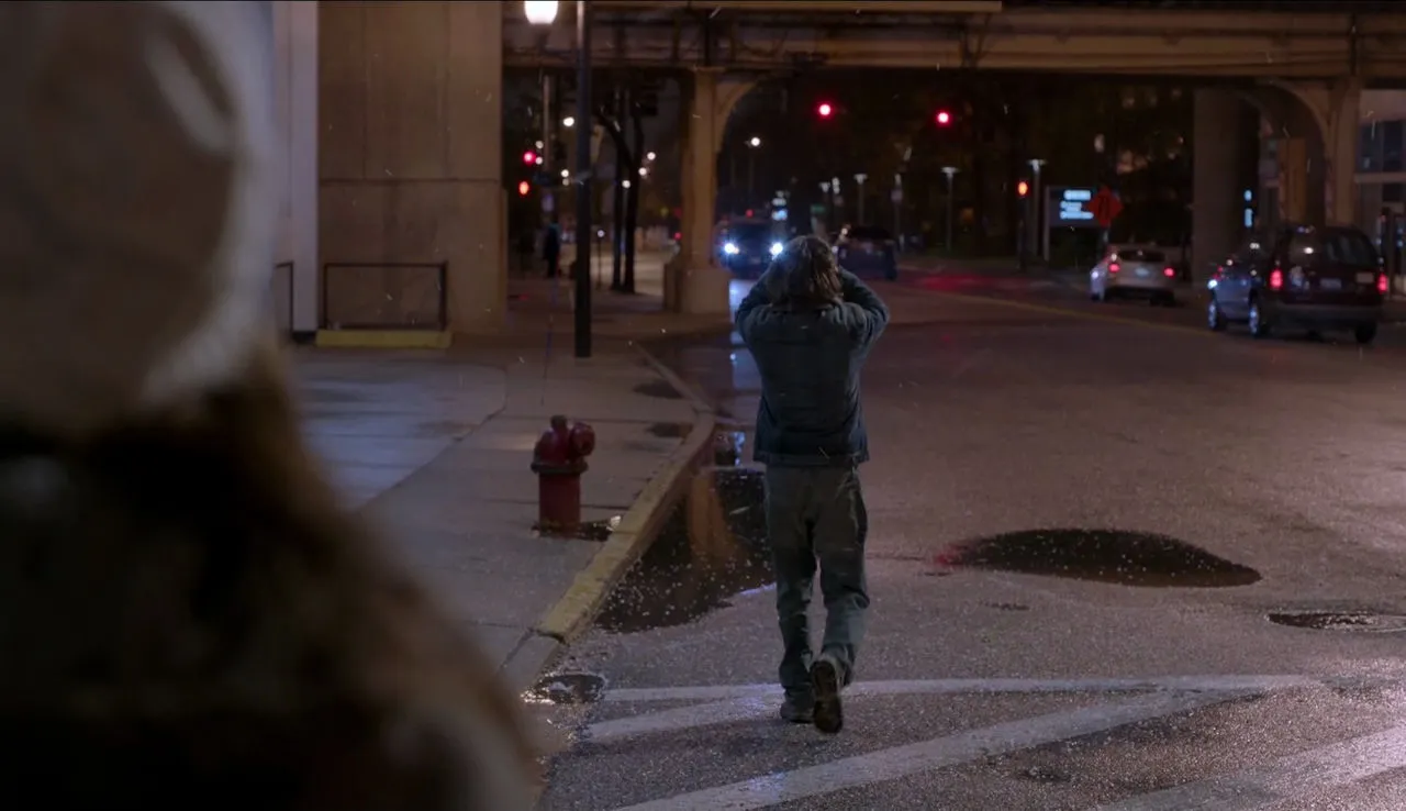 Un hombre camina de noche bajo las vías del tren en Shameless